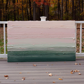 A light Coral, light pink, celadon and hunter green thickly textured abstract painting by Teodora Guererra leaning outside on a deck.