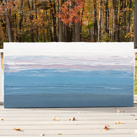 A blue, light pink, coral and white thickly textured abstract painting leaning on a deck outside in natural light by Teodora Guererra.