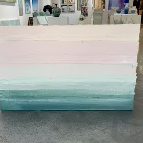 A video of a light Coral, light pink, celadon and hunter green thickly textured abstract painting by Teodora Guererra leaning on a cement floor in strong sunlight.