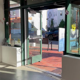 A video of a staff member walking a blue, light pink, coral and white thickly textured abstract painting by Teodora Guererra into Sorelle Gallery