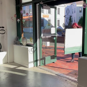A video of a staff member walking a Light Coral, light pink, celadon and hunter green thickly textured abstract painting by Teodora Guererra into Sorelle Gallery