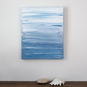 A painting is hung above a shelf. It is decorated in blue and white paint applied in thick impasto streaks to its canvas surface. Wired and ready to hang.