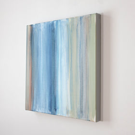 A blue, white and green streaked tan canvas is seen from an angle. Wired and ready to hang.