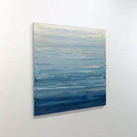 A side-view of a blue, beige, lavender and light yellow textured abstract painting by Teodora Guererra hangs on a white wall.