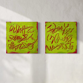 Two square abstract text-based paintings with textured chartreuse over hot raspberry pink  graffiti-style lettering, displayed side-by-side on a white wall.
