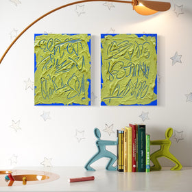 Two abstract text based painting featuring a thick, yellow-green impasto texture with blue abstract scribbled lines hang on a white wall above a desk. The scene includes a curved floor lamp, books, and decorative figurines, with a star pattern on the wall.
