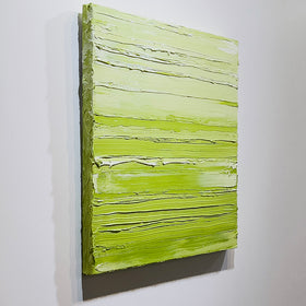 A chartreuse green and white textured abstract painting by Teodora Guererra hangs side view on a white wall.