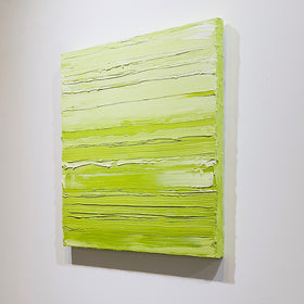 A chartreuse green and white textured abstract painting by Teodora Guererra hangs side view on a white wall.