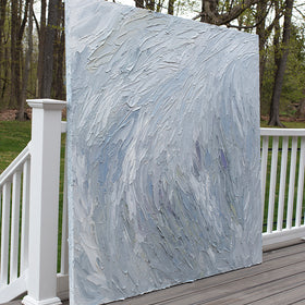 A Grey blue, light blue, lavender, celadon and white thickly textured abstract painting leaning on a deck outside in natural light by Teodora Guererra.