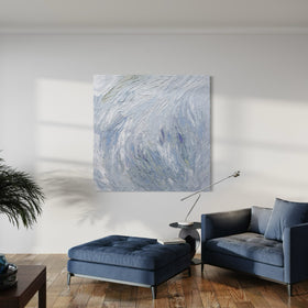 A Grey blue, light blue, lavender, celadon and white thickly textured abstract painting by Teodora Guererra hanging on a white wall in a family room. An oversized blue chair and ottoman sit in front.