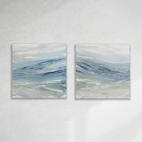 A pair of coastal paintings with blue, grey, white, cream, stone, teal, and yellow ochre paint hanging on a white wall by Teodora Guererra.