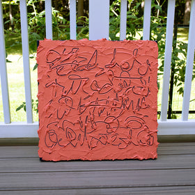 A square textured canvas painting with abstract black line work on a terracotta orange-red background, leaning against a white railing on a wooden deck with green foliage in the background.