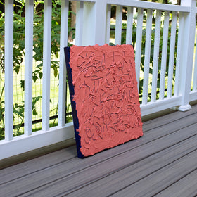 An abstract textured canvas painting in terracotta pink and dark navy blue, leaning against a white wooden railing on a gray composite deck.