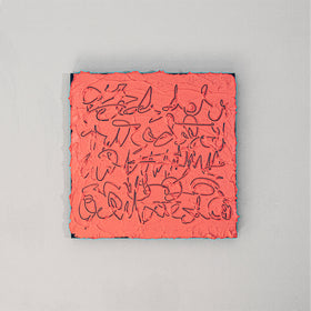 A square abstract canvas painting featuring textured coral pink paint with navy scribbled lines, displayed against a neutral light gray wall.