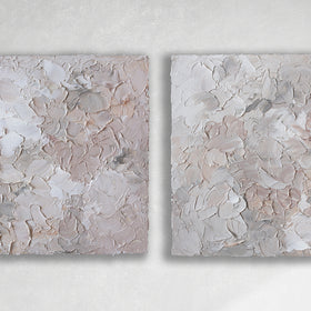 A pair of thickly textured abstract paintings in light pink, grey, coral and white by Teodora Guererra hanging on a white wall.