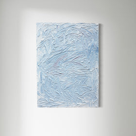 A blue and white textured painting hangs on a white wall.