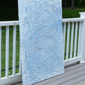 A blue and white textured sits on a deck in natural sunlight.