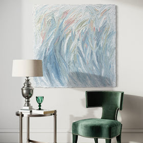 Modern interior with a green chair, side table, and abstract painting on a white wall.