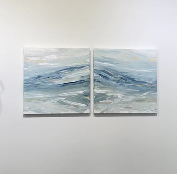 A video of a pair of coastal paintings with blue, grey, white, cream, stone, teal, and yellow ochre paint hanging on a white wall by Teodora Guererra.