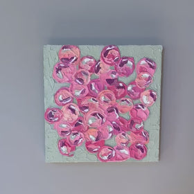 A video of a very textured abstract painting with celadon background and circle type abstract flowers in pink, peach, plum and white hangs on a white wall.