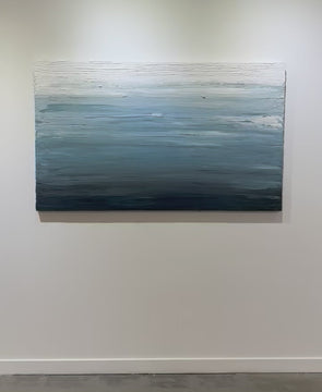 A video of a dark navy blue, light blue, blue, and white thickly textured abstract painting hanging on a white wall in natural light by Teodora Guererra.