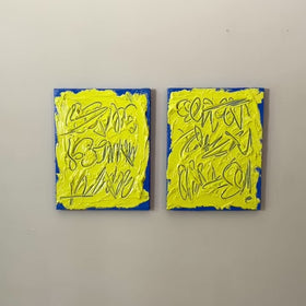 A video of two abstract text based painting featuring a thick, yellow-green impasto texture with blue abstract scribbled lines and a bright blue base hanging on a wall.