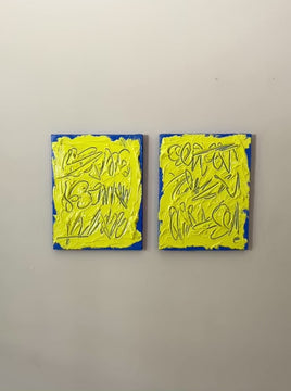 A video of two abstract text based painting featuring a thick, yellow-green impasto texture with blue abstract scribbled lines and a bright blue base hanging on a wall.