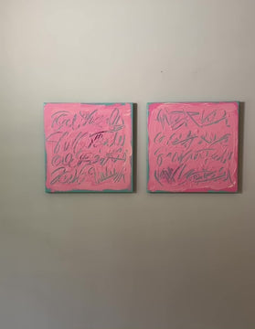 A video of two square pink text based paintings with writing into the surface with various tools, carving fluid script that reveals the teal color hidden below. Displayed side-by-side on a white wall.
