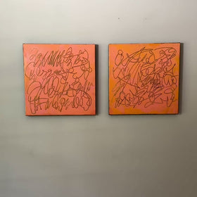 A video of two abstract text based paintings in orange and pink tones hanging on a white wall.