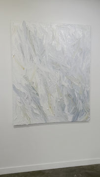 A video of an abstract heavily textured painting with blue, grey, white, stone, teal, and yellow ochre hanging on a white wall in natural light by Teodora Guererra.
