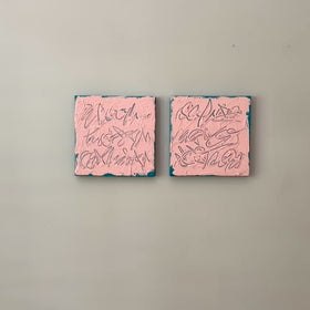 A video of two square abstract texted based paintings with pink backgrounds, teal textured brushstrokes, and teal line-like calligraphic forms, displayed side by side on a white wall.