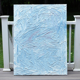 A blue and white textured sits on a deck in natural sunlight.