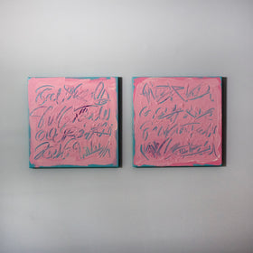Two square pink text based paintings with writing into the surface with various tools, carving fluid script that reveals the teal color hidden below. Displayed side-by-side on a white wall with soft diagonal shadows.