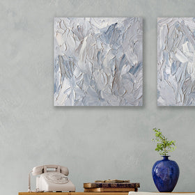 A painting is hanging on a wall. Its surface is decorated with white, blue and grey paint in a thick impasto. Hangs over a desk with rotary dial phone.Wired and ready to hang.