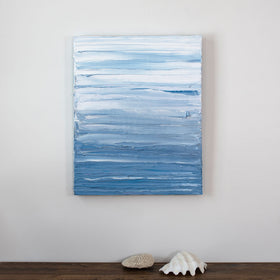 A painting is hung above a shelf. It is decorated in blue and white paint applied in thick impasto streaks to its canvas surface. Wired and ready to hang.