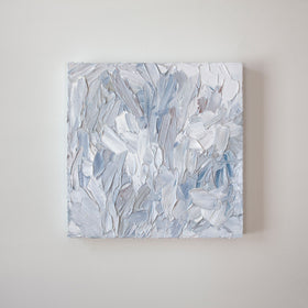 A painting is hanging on a wall. Its surface is decorated with white, blue and grey paint in a thick impasto. Wired and ready to hang.
