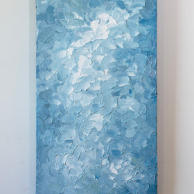 A blue and white abstract painting by Teodora Guererra hangs vertically on a white wall.