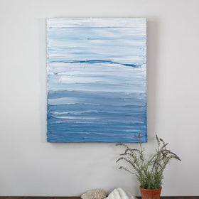 A painting is hung above a shelf. It is decorated in blue and white paint applied in thick impasto streaks to its canvas surface. Wired and ready to hang.